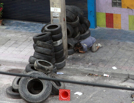 A local photographer attempts to get s photograph while hiding behind a wall of tires 