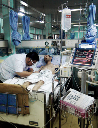 A nurse attends to Gareth Davies in Rajavithi Hospital on March 25, 2012