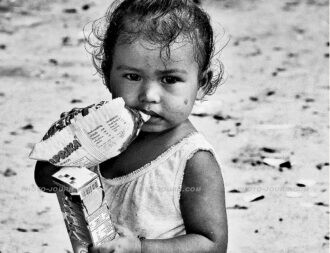 A box of milk and packet of snacks from visiting charity workers is a weekly "luxury" for this child living in Pattaya's slums