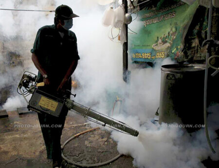 A public health worker fogging against mosquitoes in Bangkok