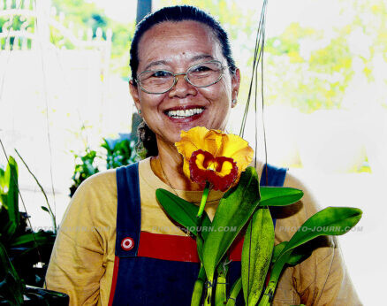Siriporn Pongsang, owner of Siriporn Orchid Farm in Pattaya, with a bloomy Cattleya orchid