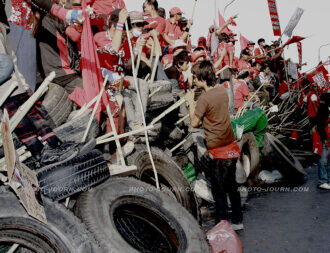 Red-shirt protester atop their bamboo and tire fort on Rama IV Rd. in 2010.