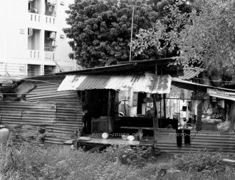 Obscured mostly by trees, residents of this Pattaya apartment complex remain oblivious to the living conditions of the people next door