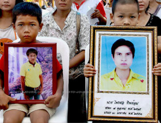 Two children mourn their fathers, killed in clashes between red-shirt protesters and the Thai Army on April 10, 2010 at Si Yak Kok Woe intersection