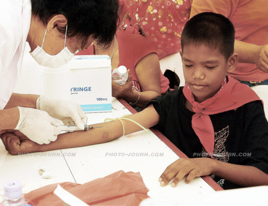 To demonstrate their willingness to spill their own blood to achieve political reform, thousands of red-shirt protesters donated blood that was later to be spilled at the gates of the parliament, amongst them this 11-year-old boy, a symbolism of the political awakening and empowerment of the rural and lower socio-economic sectors of the Thai population